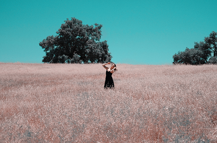 Woman in field with tree