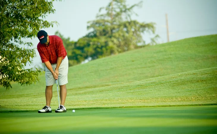 Man playing golf in polo shirt