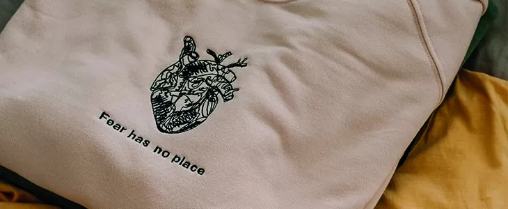 embroidered text and complex design on sweatshirt