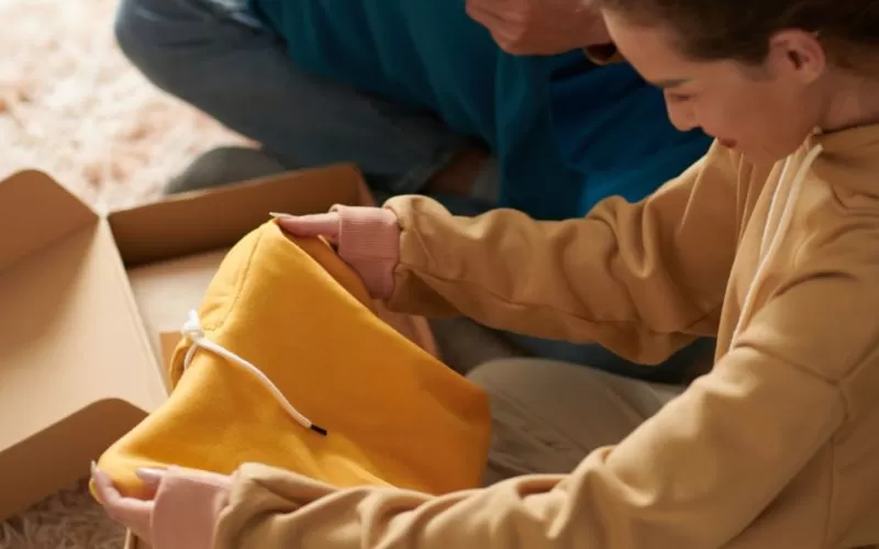 Hoodie merchandise being unboxed.
