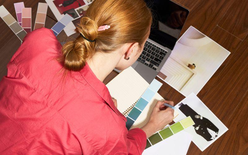 Fashion designer using a laptop to assist fashion designing.