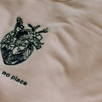 embroidered text and complex design on sweatshirt